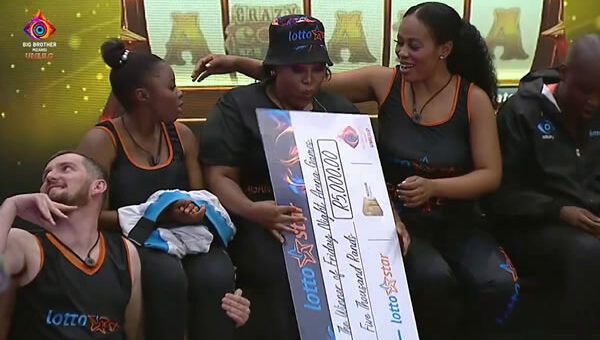 Mandy Hagan holding a R5,000 cheque after winning Big Brother Mzansi Season 5 Week 6 Lottostar Friday night arena games on day 40 of the show
